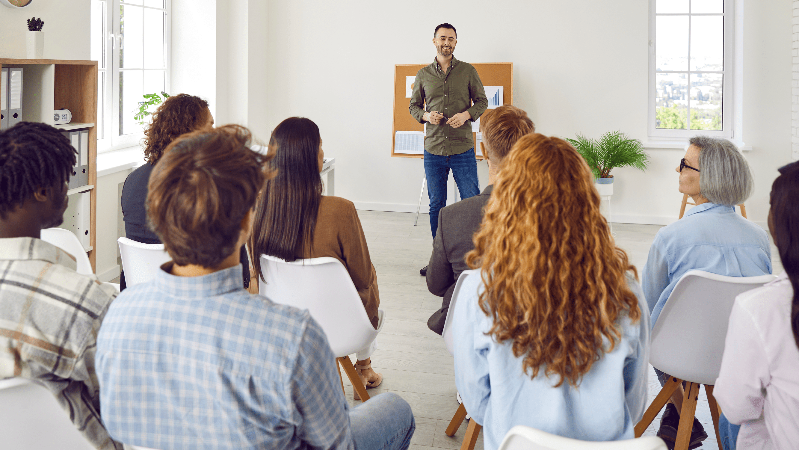 An educator delivering a lecture to a group of employees in a room setting
